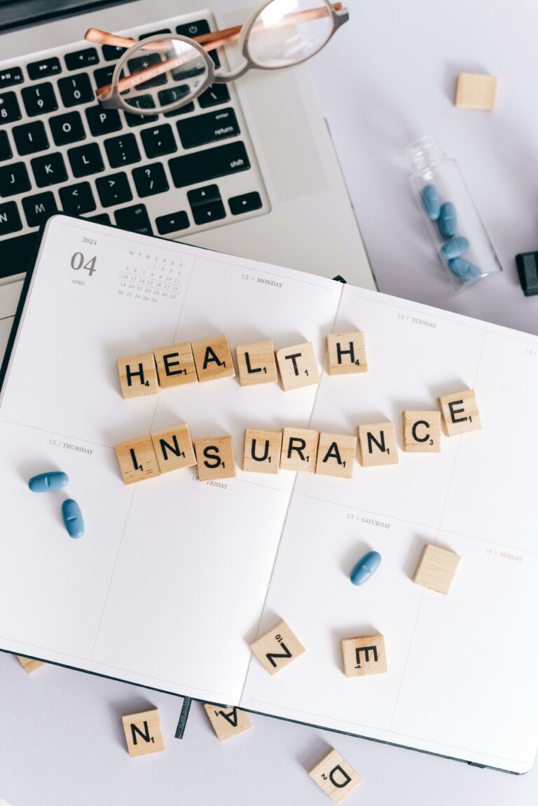 "health insurance" spelled out in scrabble title on top of a notebook